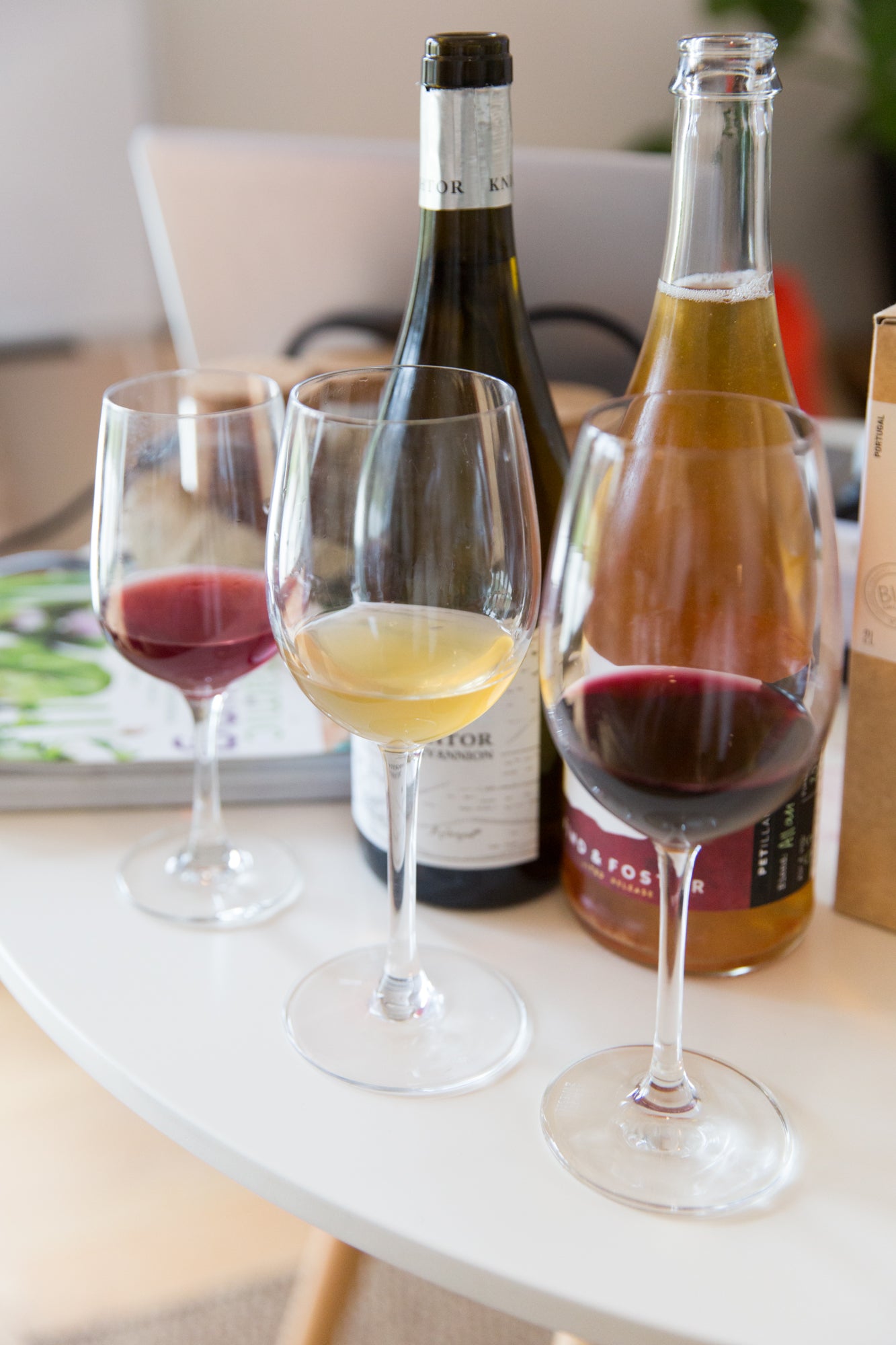 Three glasses of natural wine and two bottles of wine